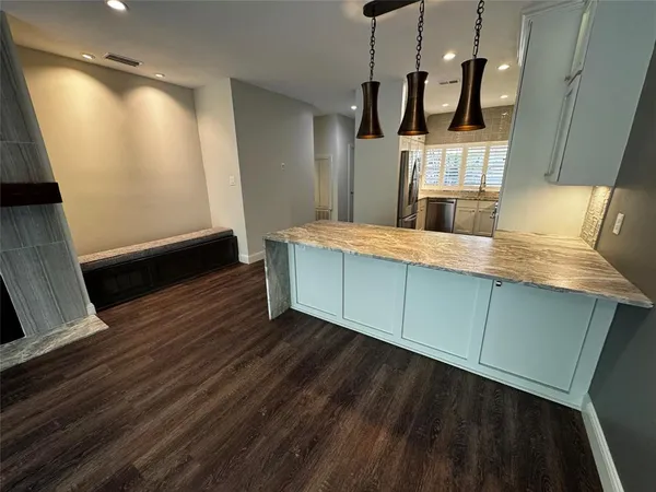 a kitchen with kitchen island wooden floors and stainless steel appliances