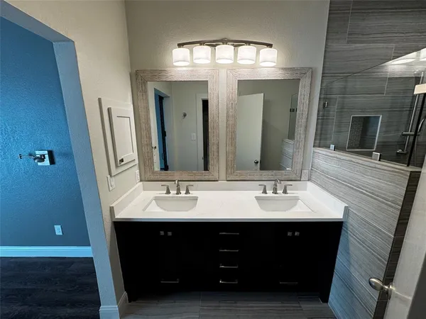 a bathroom with a double vanity sink and a mirror