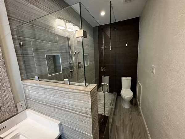 a bathroom with a toilet a sink and shower