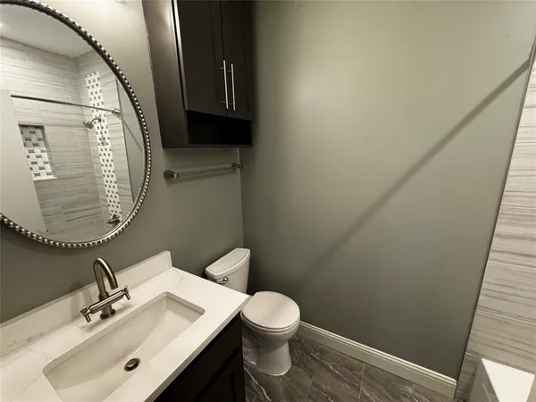 a bathroom with a sink mirror and toilet