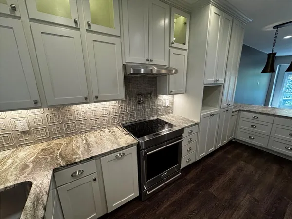 a kitchen with stainless steel appliances granite countertop a stove and a granite counter tops