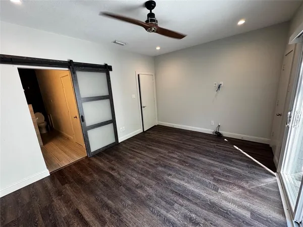 a view of empty room with wooden floor