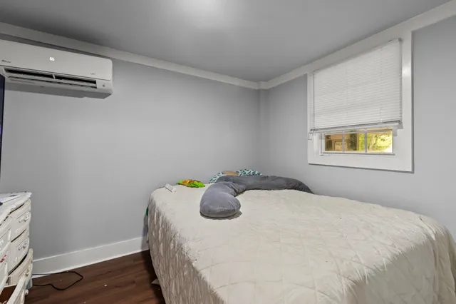 a bedroom with a bed and painting on the wall