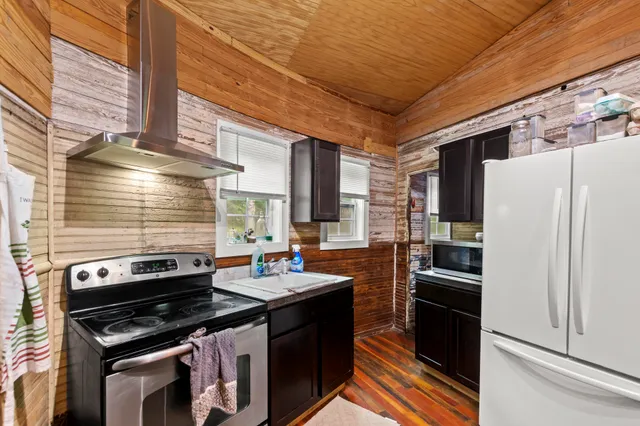 a kitchen with stainless steel appliances kitchen island granite countertop a table chairs and a stove