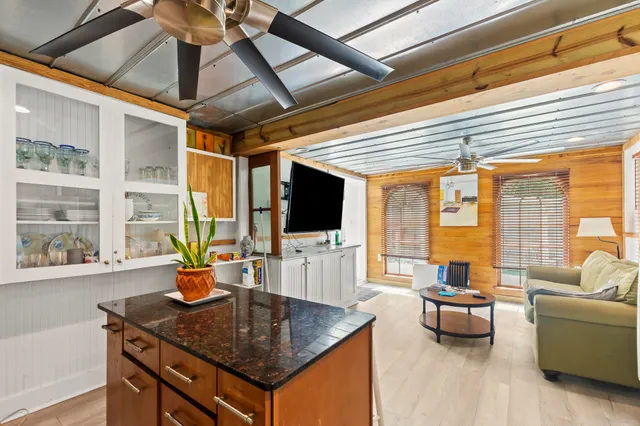 a living room with furniture a flat screen tv and a large window