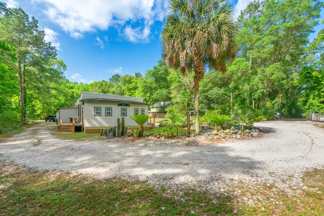 a view of a house with backyard and trees