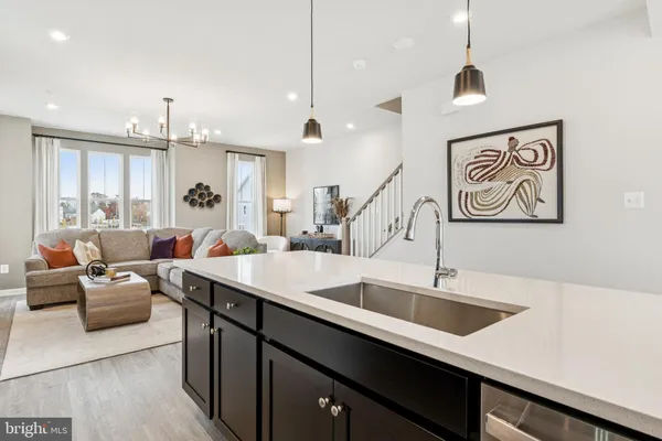 a hall with kitchen island a sink and a large window