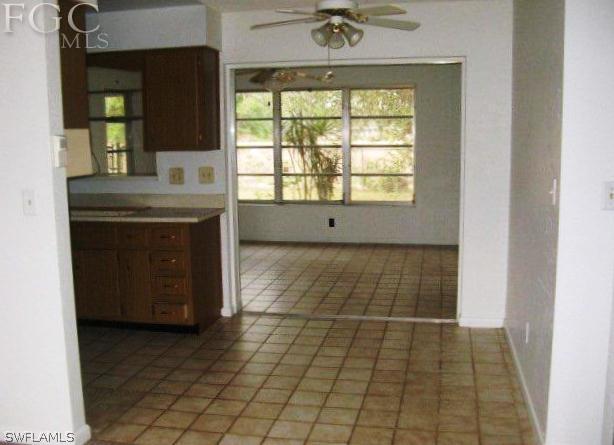207 Davis Road Lehigh Acres, FL 33936 - Photo 3 of 10 an empty room with a fireplace and windows