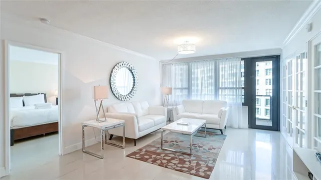 a living room with furniture a rug a lamp and a large window