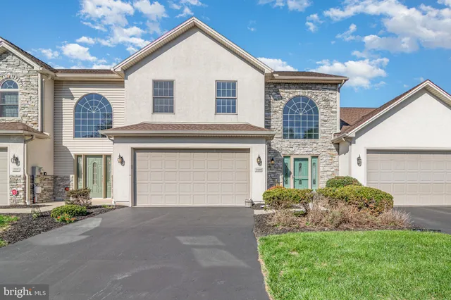 a front view of a house with a garden and plants