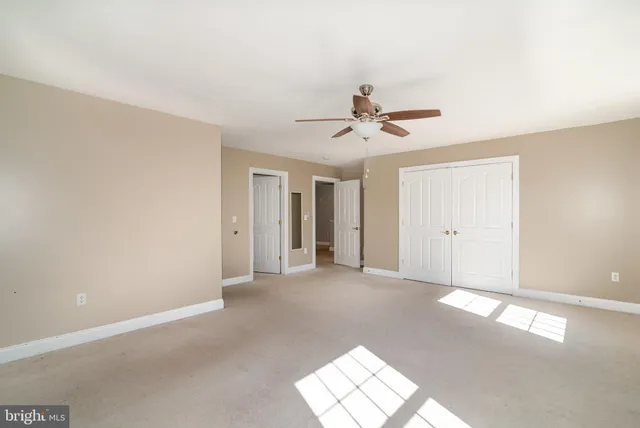 a view of a big room with windows and chandelier fan