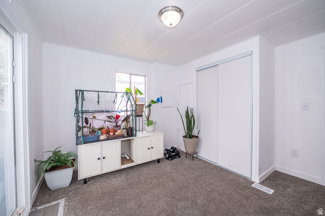 2600 North Hill Field Road, Unit 5 Layton, UT 84041 - Photo 20 of 33 Neutral white walls with textured paneling, gray carpet flooring, and a large sliding door closet