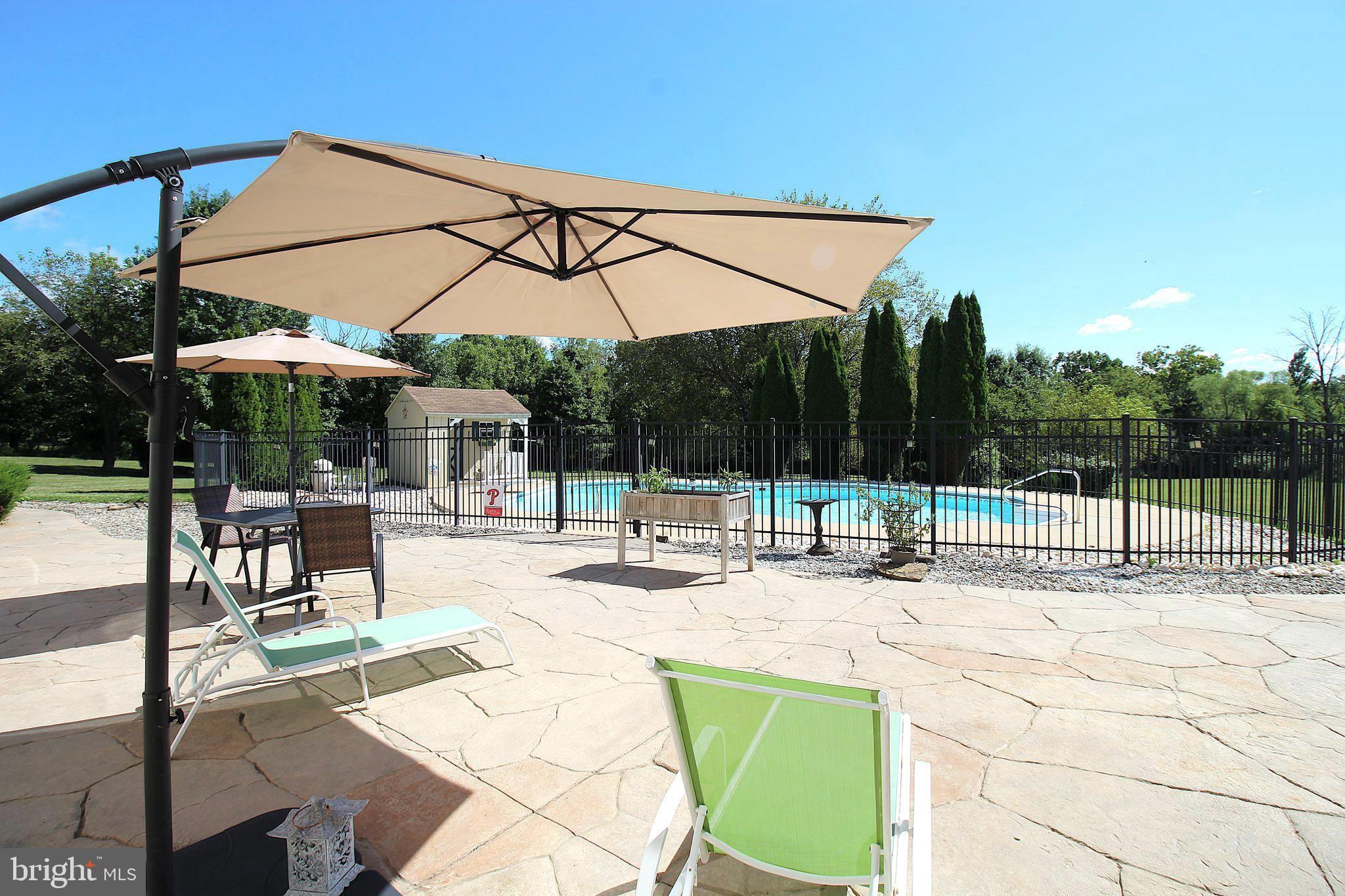 193 Curley Mill Road Chalfont, PA 18914 - Photo 46 of 49 a swimming pool with table and chairs under an umbrella
