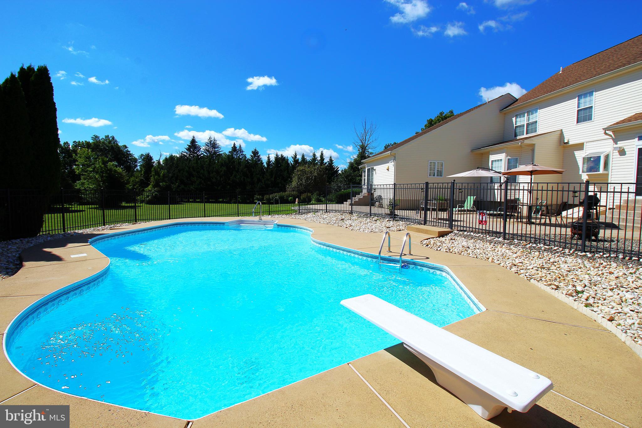 193 Curley Mill Road Chalfont, PA 18914 - Photo 49 of 49 a view of a swimming pool with lawn chairs under an umbrella