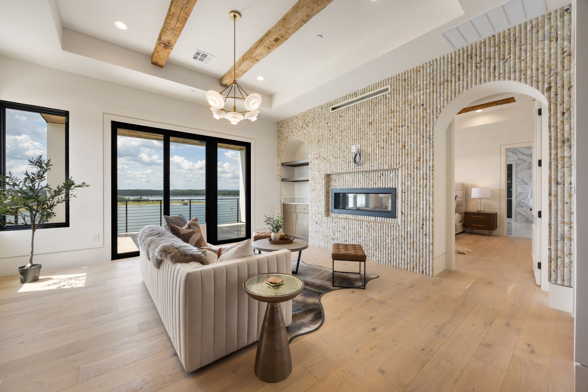1496 Buffalo Gap Road Lakeway, TX 78734 - Photo 18 of 37 Elegant living space showcasing a water view, warm wooden beams, and a modern fireplace.