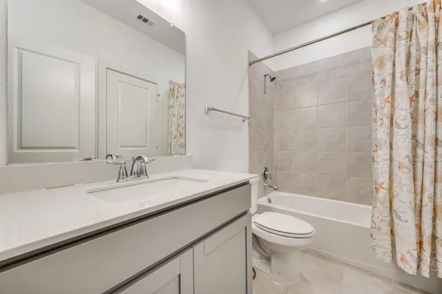 a bathroom with a granite countertop sink a toilet and shower