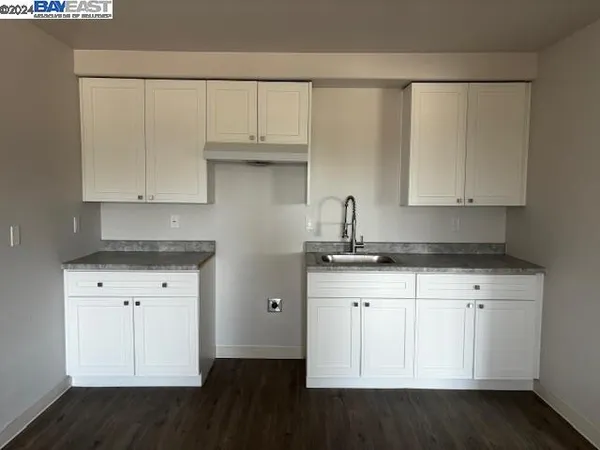 a kitchen with granite countertop white cabinets and a sink