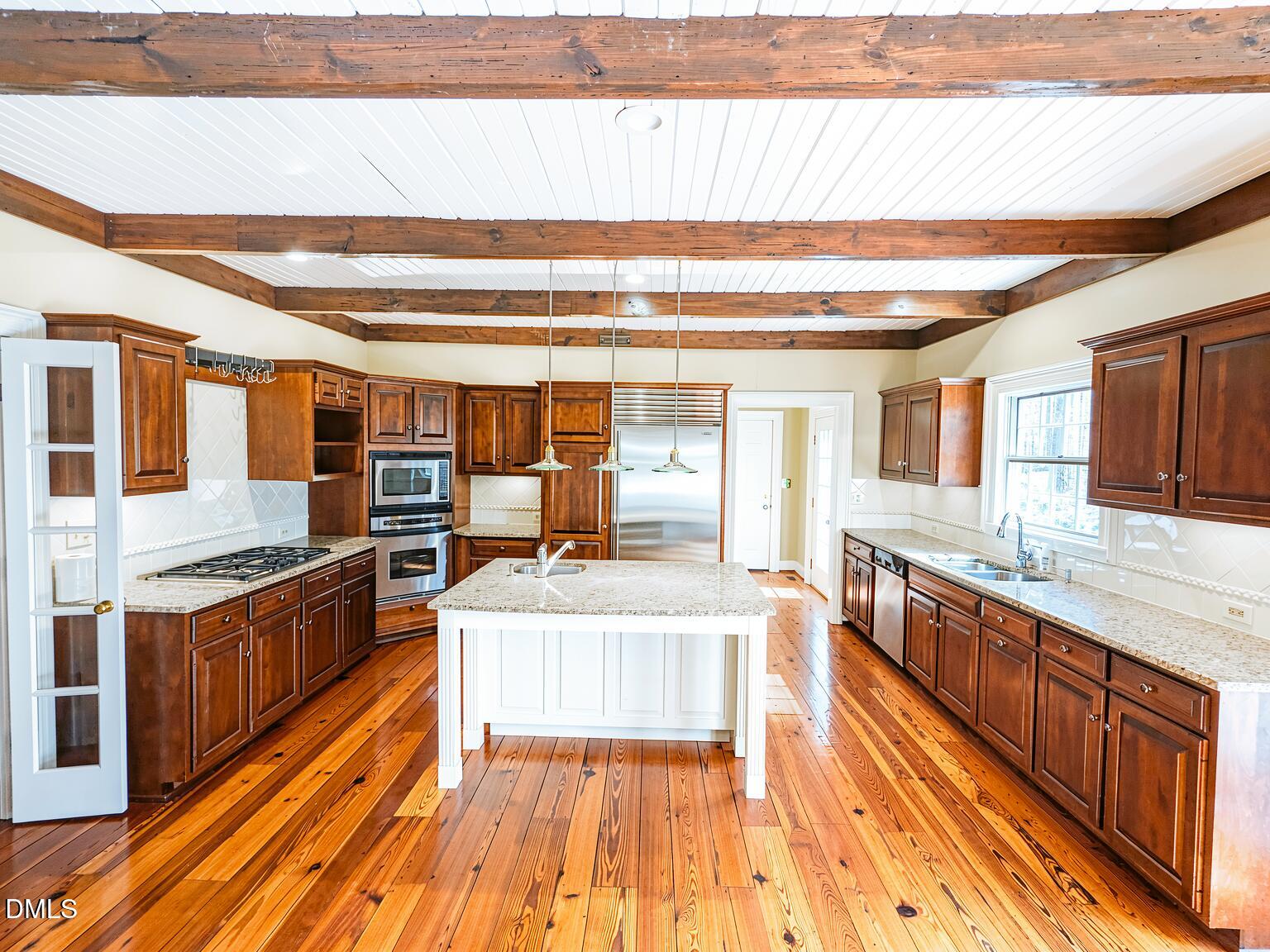 4901 Stoneridge Drive Raleigh, NC 27612 - Photo 26 of 50 a large kitchen with stainless steel appliances granite countertop a lot of counter space and wooden floor