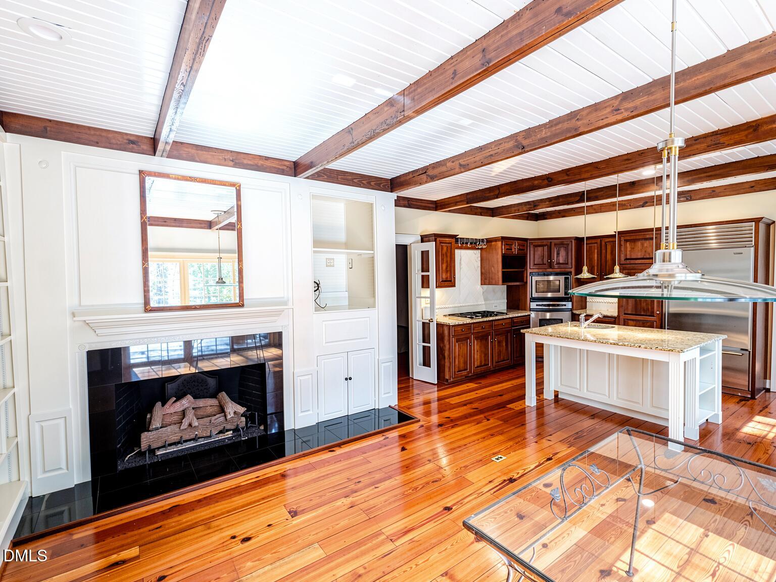 4901 Stoneridge Drive Raleigh, NC 27612 - Photo 7 of 50 a kitchen with a stove kitchen island wooden floor and stainless steel appliances