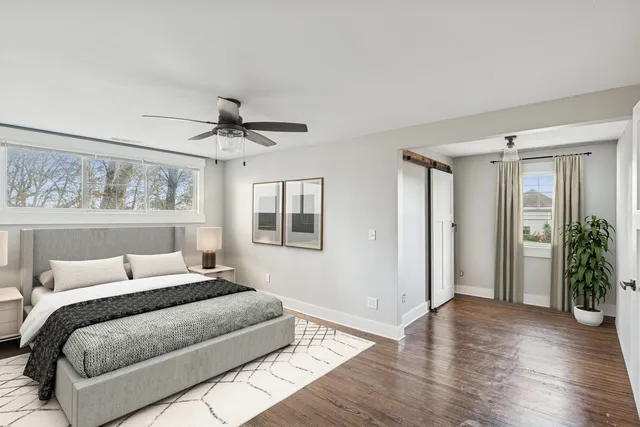 a bedroom with a large bed and a ceiling fan