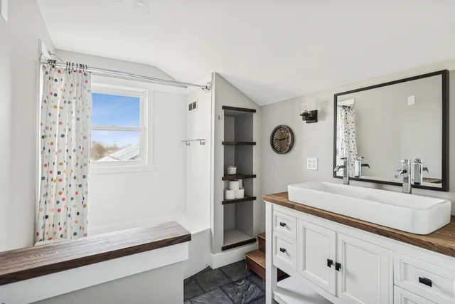 a bathroom with a sink a mirror and a shower