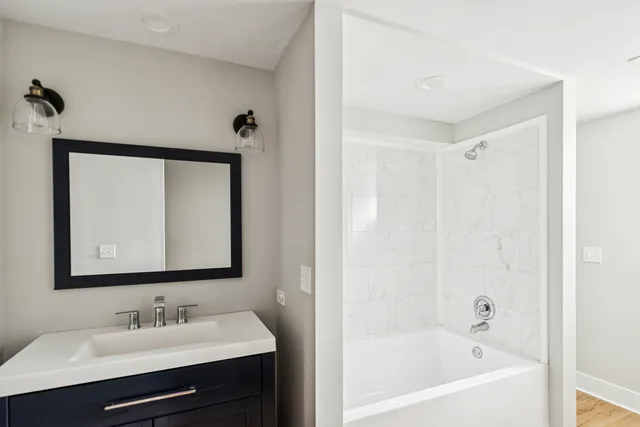 a bathroom with a bathtub sink and mirror