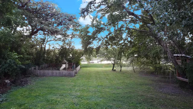a view of a gate and barn in the background