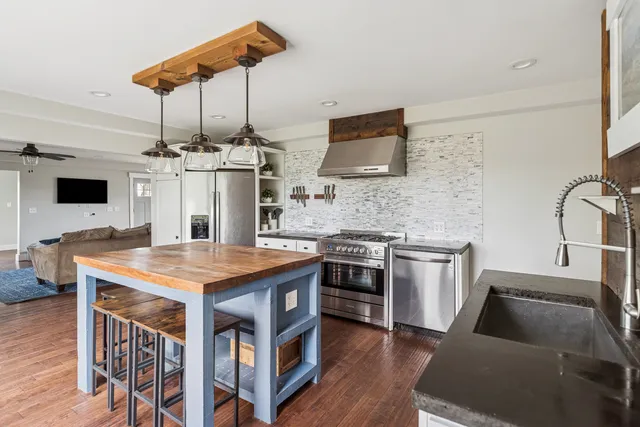 a kitchen with stainless steel appliances kitchen island granite countertop a stove a sink and a microwave