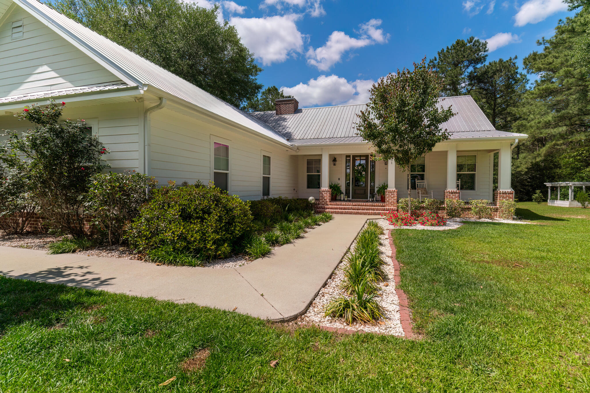 4351 Poverty Creek Road Crestview, FL 32539 - Photo 4 of 53 a view of a white house with a yard patio and plants