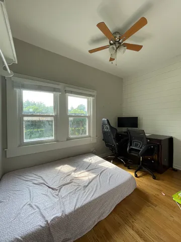 a bedroom with a bed and wooden floor