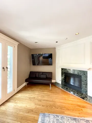 a bedroom with furniture a fireplace and wooden floor