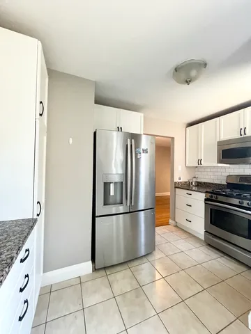 a kitchen with stainless steel appliances granite countertop a refrigerator and a stove top oven