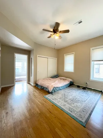 a spacious bedroom with a bed and wooden floor