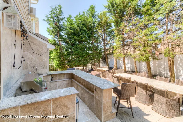 a view of a patio with table and chairs potted plants and a large tree
