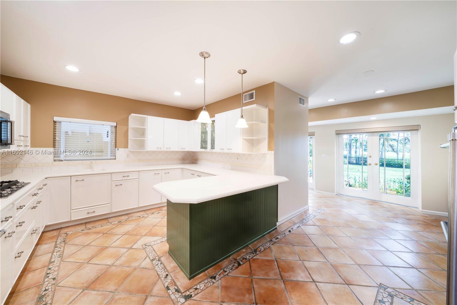5801 Alton Road Miami Beach, FL 33140 - Photo 14 of 35 a kitchen with stainless steel appliances granite countertop a sink and a stove