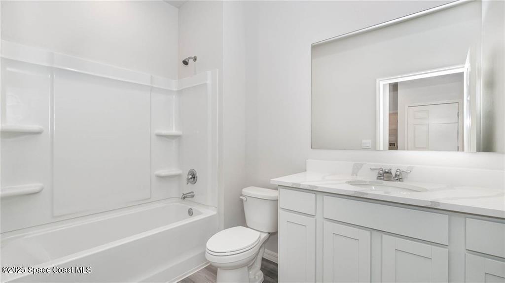 9036 Orchid Reserve Circle Sebastian, FL 32958 - Photo 22 of 25 a bathroom with a granite countertop sink a toilet and a bathtub