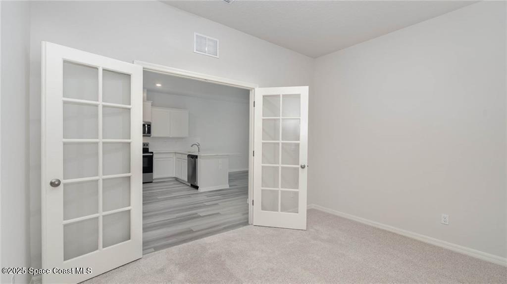 9036 Orchid Reserve Circle Sebastian, FL 32958 - Photo 24 of 25 an empty room with wooden floor and windows