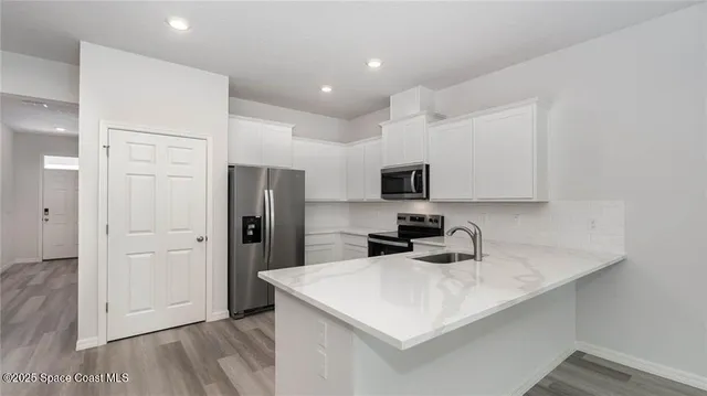 a kitchen with a sink a refrigerator and cabinets