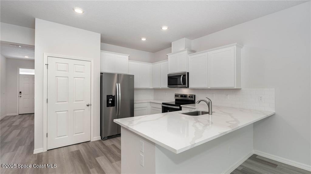 9036 Orchid Reserve Circle Sebastian, FL 32958 - Photo 8 of 25 a kitchen with a sink a refrigerator and cabinets