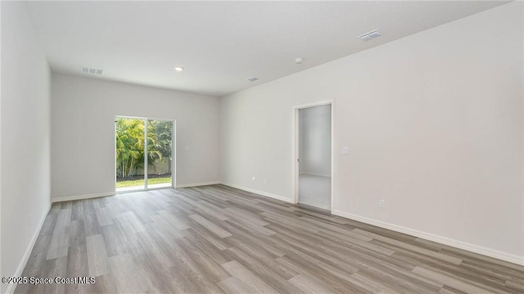 9036 Orchid Reserve Circle Sebastian, FL 32958 - Photo 10 of 25 a view of an empty room with wooden floor and a window