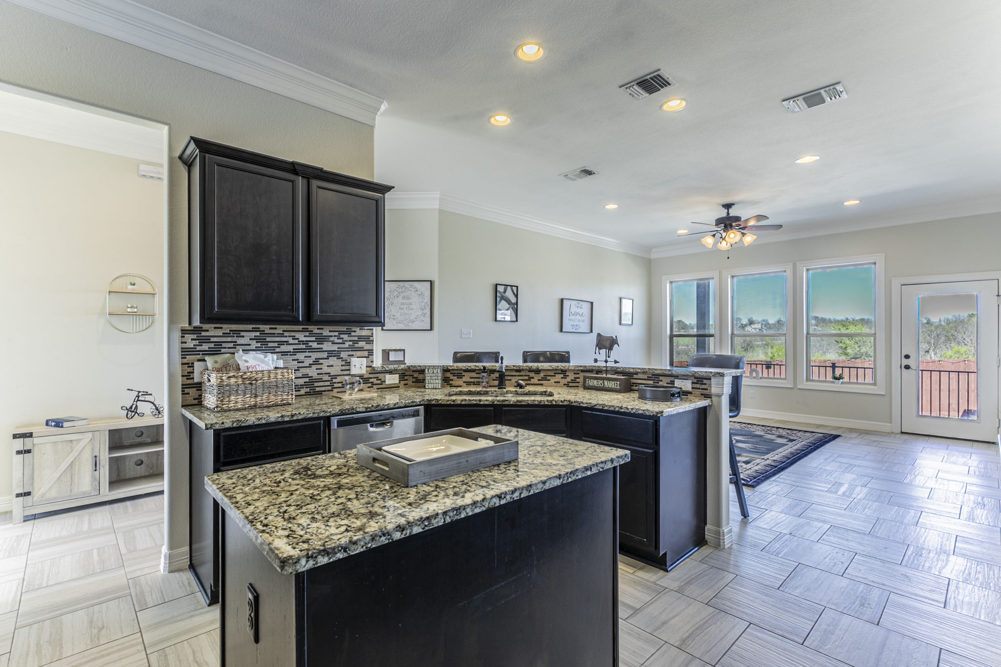 300 Magan Lane Jarrell, TX 76537 - Photo 6 of 33 Kitchen with a peninsula, a center island, crown molding, backsplash, and dishwasher