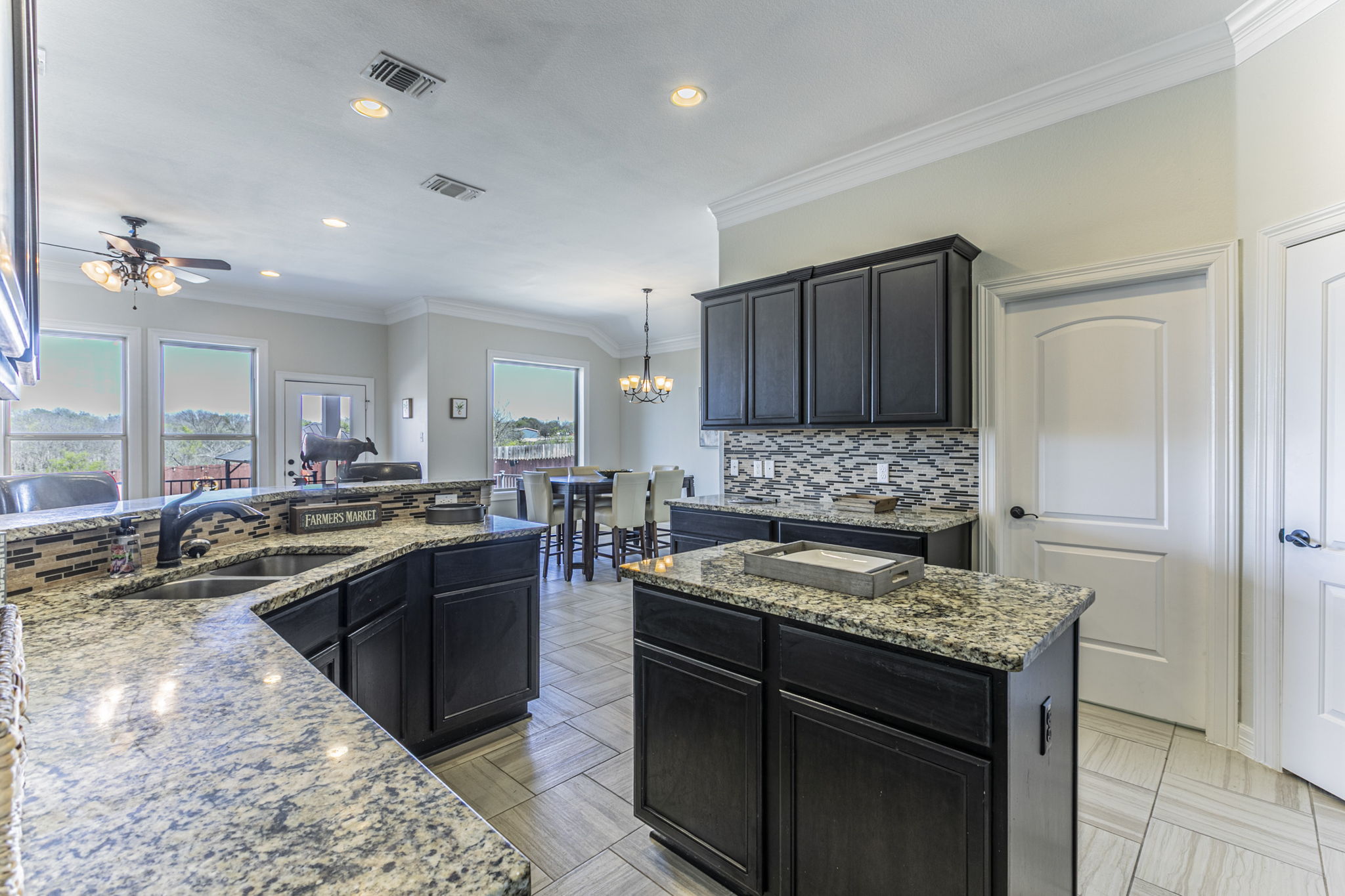 300 Magan Lane Jarrell, TX 76537 - Photo 7 of 33 Kitchen with a center island, light stone counters, ornamental molding, hanging lights, and a ceiling fan