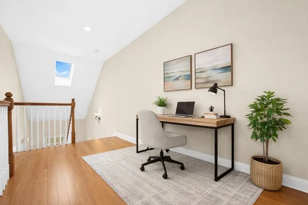 a view of a workspace with furniture and wooden floor