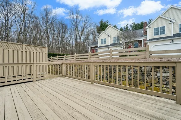 a view of a white house with a small yard and wooden fence