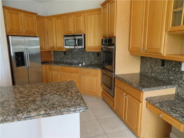 a kitchen with stainless steel appliances granite countertop a refrigerator stove and oven