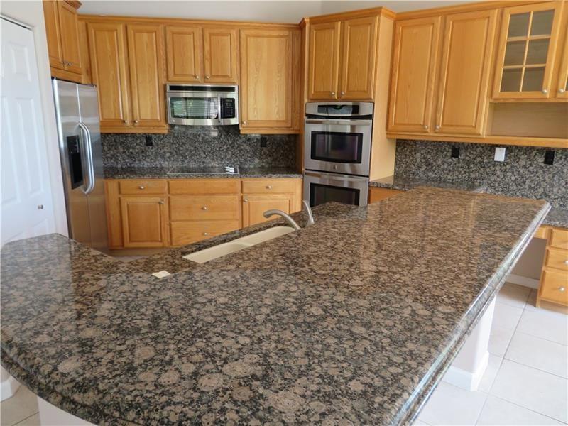 19430 Southwest 30th Street Miramar, FL 33029 - Photo 10 of 44 a kitchen with stainless steel appliances granite countertop a stove a sink and a microwave