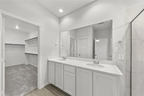 a bathroom with a double vanity sink and mirror