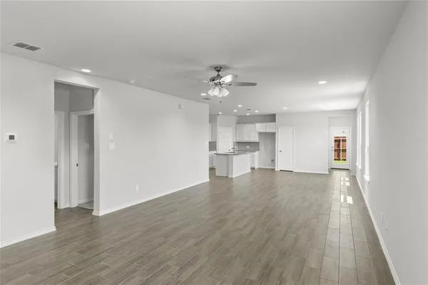 a view of an empty room with wooden floor