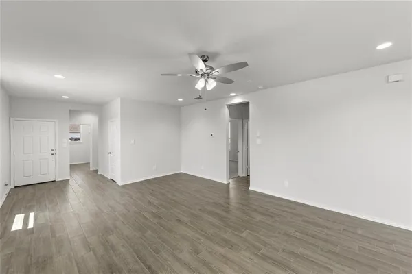 a view of hallway with bathroom and wooden floor