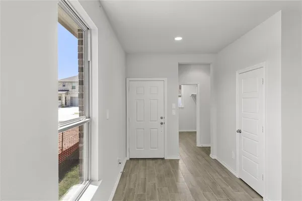 an empty room with wooden floor and ceiling fan